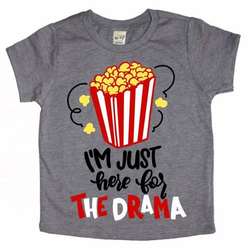 May include: Gray t-shirt with a red and white striped popcorn bucket and the text "I'm just here for the drama".