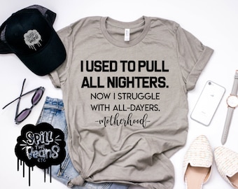 May include: A heather grey t-shirt with black text that reads "I used to pull all-nighters. Now I struggle with all-dayers. -Motherhood-"
