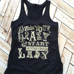 May include: Black tank top with gold lettering that reads "Hide Your Crazy & Start Acting Like A Lady".