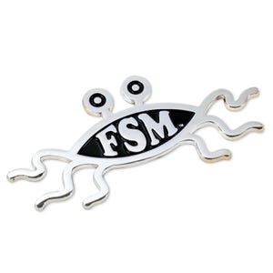 May include: Silver-colored metal pin with a black and white image of a three-eyed creature with the letters "FSM" in the center. The creature has tentacles.