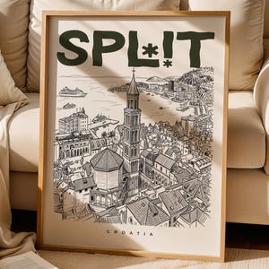 Puede incluir: Una impresión artística enmarcada con una ilustración en blanco y negro de Split, Croacia. La palabra "SPL!T" está en la parte superior en letras verde oscuro, con "CROATIA" debajo. La obra representa edificios, una torre y el mar.