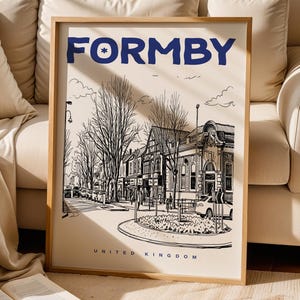 Puede incluir: Un póster enmarcado con una ilustración en blanco y negro de Formby, Reino Unido. La obra de arte representa una escena callejera con edificios, árboles y coches. La palabra "Formby" está escrita en azul marino en la parte superior.