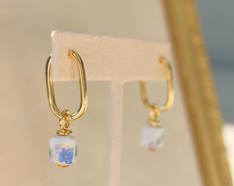 Pendientes Huggie rellenos de oro de 14 k: dije de cerámica con flor azul