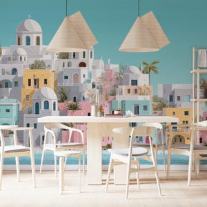 May include: A dining room scene featuring a large mural of a Greek village with white buildings, blue accents, and a turquoise sky. A light wood table and chairs are in the foreground, with two pendant lights hanging above. The room has a bright and airy feel.