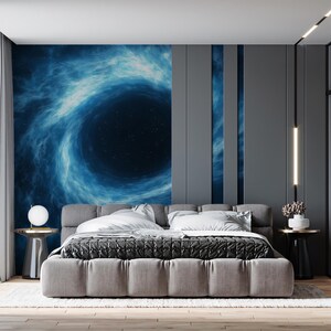 May include: A modern bedroom featuring a large gray upholstered bed with a patterned comforter and white pillows. The headboard wall has a mural of a blue and black galaxy. Two small side tables with lamps and decor complete the room.