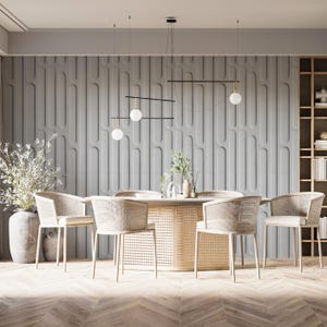 May include: A modern dining room set featuring a round table with a woven base and six matching chairs. The chairs have woven backs and light-colored cushions. The room has a gray accent wall and a wooden floor.