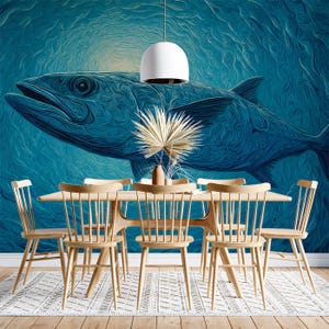 Può includere: Un set da pranzo con un grande murale di pesce blu sulla parete. Il set comprende un tavolo in legno, sei sedie in legno e un centrotavola decorativo. Una lampada a sospensione bianca è appesa sopra il tavolo.