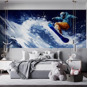 Può includere: Una camera da letto con un grande murale di uno snowboarder in azione. Il murale è sopra un letto grigio con cuscini bianchi e una coperta grigia. Un orsacchiotto grigio è ai piedi del letto. Due comodini bianchi fiancheggiano il letto.