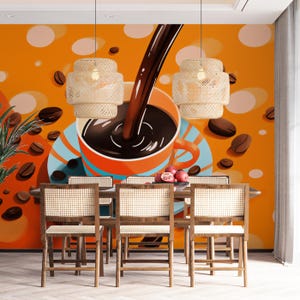 Op de afbeelding: Een eethoek met een koffiethema muurschildering. De muurschildering toont een grote koffiekop met koffie die erin wordt gegoten, omringd door koffiebonen en oranje en witte cirkels. De set bevat een houten tafel en stoelen met geweven rugleuningen.
