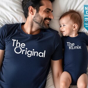 May include: Navy blue t-shirt with the text "The Original" and a navy blue baby bodysuit with the text "The Remix". The matching outfits are for a parent and child.