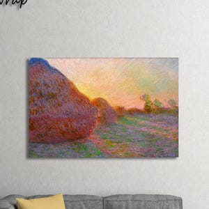 Puede incluir: Impresión en lienzo de una pintura de paisaje que representa un campo con montones de heno al atardecer. La obra de arte utiliza colores cálidos, con tonos rojos, naranjas y amarillos en el cielo y los montones de heno. El texto "Gallery Wrap" está en la esquina superior izquierda.