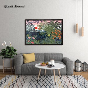 May include: A framed art print featuring a vibrant jungle scene with lush greenery, orange fruit, and a red sun against a pink sky. The artwork is displayed above a gray sofa with a yellow pillow, a round coffee table, and a patterned rug. The frame is black and the text "Black Frame" is in the upper left corner.