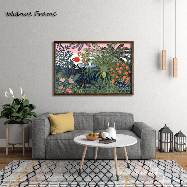 May include: A framed art print featuring a vibrant jungle scene with lush green foliage, orange fruit, and a red sun against a pink sky. The artwork is in a walnut frame, adding a touch of warmth to the colorful illustration.