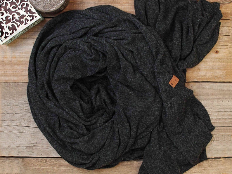 May include: A dark gray knitted scarf with a brown leather tag that says "L.C.K."