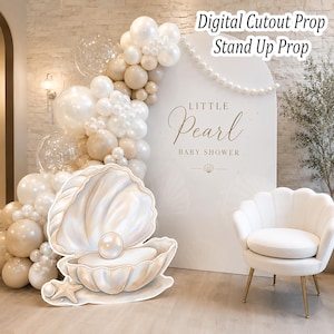 May include: A white arched backdrop featuring the text Little Pearl Baby Shower with a string of pearls, accompanied by a large cutout prop of an open seashell with a pearl inside and a starfish, next to a white scalloped chair and balloon arch.