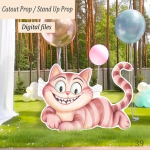 Könnte beinhalten: Ausschnitt-Requisite des Grinsekatze aus Alice im Wunderland, liegend mit breitem Grinsen. Die Katze ist rosa und weiß gestreift. Der Hintergrund enthält Ballons und den Text "Cutout Prop / Stand Up Prop" und "Digital files".