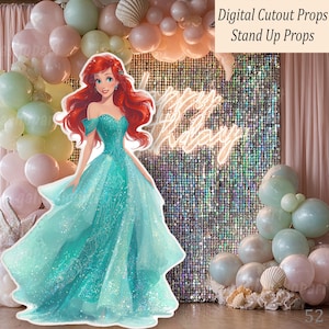 A teal Mermaid princess cutout prop with red hair, set against a backdrop of balloons, seashells, and a sequined wall with neon "Happy Birthday" lettering. The image is labeled "Digital Cutout Props Stand Up Props."