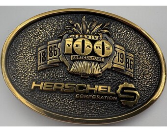 Hebilla de cinturón ovalada de latón macizo conmemorativa de 100 años de agricultura de Herschel Corporation (1986)