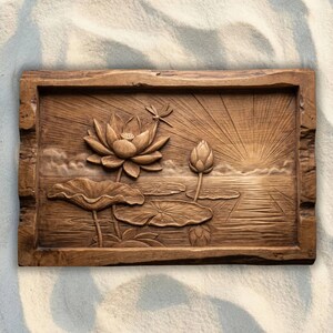 May include: A rectangular wooden wall plaque featuring a relief carving of a lotus flower, a lotus bud, and a dragonfly. The scene depicts a sunrise over water with radiating sunbeams, lily pads, and rippling water textures in a natural wood tone.