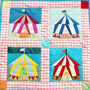 Newborn baby quilt with four circus tents.