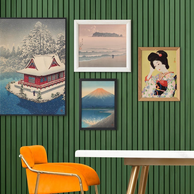May include: A wall gallery featuring five framed prints. The prints are all in black or white frames and feature Japanese-inspired artwork. The prints include a snowy landscape with a red house, a mountain scene, a seascape, and a portrait of a woman in traditional Japanese clothing.