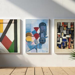 May include: Three framed abstract paintings with geometric shapes and colors. The paintings are in white frames and are hanging on a white wall.