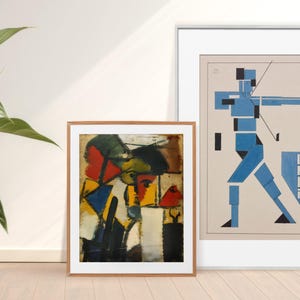 May include: Two framed abstract art prints. The print on the left is a colorful geometric design with red, yellow, blue, and black. The print on the right is a blue and white geometric design with the word "HEKA" in black.