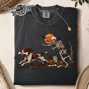 Camiseta engraçada de Halloween com um Pointer Alemão de Pelo Curto, camiseta de Halloween para cães, camiseta engraçada com um esqueleto perseguindo um cachorro, presente para amantes de cães de caça no outono.