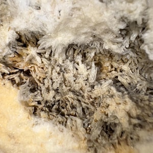 May include: Close-up of a geode with a white and brown interior. The geode is filled with small, white crystals.