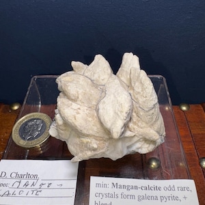 May include: A cluster of white mangan-calcite crystals with a label that reads "min: Mangan-calcite odd rare, crystals form galena pyrite, + blend, loc: Peru, 2x2" £25.
