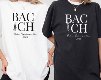 Może przedstawiać: Dwie oversize'owe koszulki z nadrukiem "BAC Squad CH Palm Springs, Ca 2025" na przodzie. Jedna koszulka jest biała, a druga czarna.
