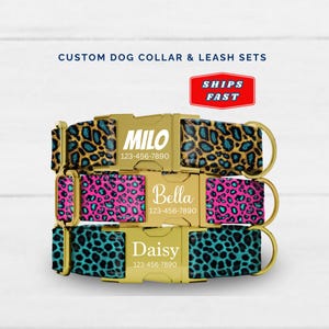 May include: Three custom dog collars with gold-colored buckles and D-rings. The collars feature personalized names and phone numbers. The top collar has a tan and teal leopard print, the middle is pink and teal, and the bottom is teal and black.