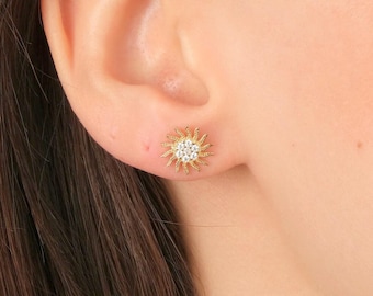 Peut inclure: Boucles d'oreilles clous en forme de soleil dorées avec des pierres en zircone cubique transparentes.