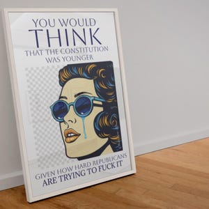 Könnte beinhalten: Gerahmter Pop-Art-Druck mit einer weinenden Frau mit blauer Sonnenbrille. Der Druck enthält den Text "YOU WOULD THINK THAT THE CONSTITUTION WAS YOUNGER" und "GIVEN HOW HARD REPUBLICANS ARE TRYING TO FUCK IT."
