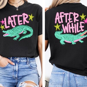 May include: Black t-shirt with a teal alligator graphic and the text "LATER" in pink on the front. The back of the shirt has the text "AFTER WHILE" and the same alligator graphic. Yellow and pink stars accent the text.
