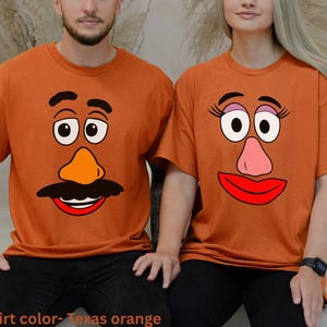 May include: Two orange t-shirts with cartoon potato head faces. One shirt features a mustache and a male face, the other has eyelashes and a female face. The shirts are short-sleeved and the text "Shirt color- Texas orange" is at the bottom.