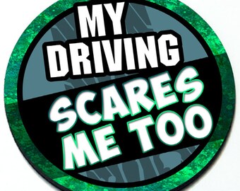May include: A round black and green sticker with the text "My driving scares me too" in white.