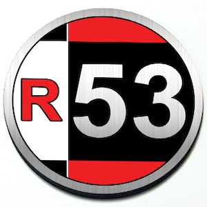 Peut inclure: Un autocollant rond et métallique avec une bordure argentée. Le design présente un fond divisé : blanc à gauche et noir à droite. Une bande rouge divise le haut et le bas, avec le chiffre "53" en argent et la lettre "R" en rouge.
