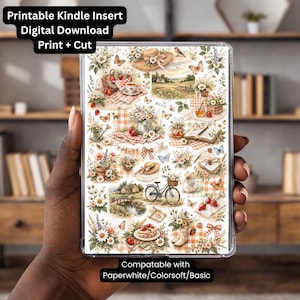 May include: A Kindle insert with a floral and countryside theme. The insert features illustrations of flowers, butterflies, hats, and a bicycle. Text at the top reads "Printable Kindle Insert Digital Download Print + Cut". The bottom text says "Compatable with Paperwhite/Colorsoft/Basic".