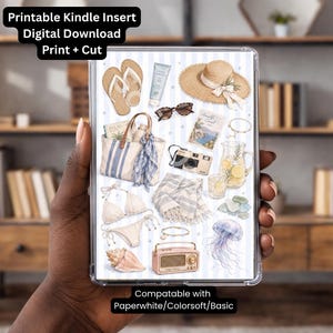 May include: A digital download Kindle insert with a beach theme. The insert features illustrations of a straw hat, sunglasses, a beach bag, a camera, and a bikini. The text "Printable Kindle Insert Digital Download Print + Cut" is at the top.