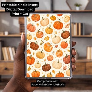 May include: A rectangular digital download printable Kindle insert featuring a repeating pattern of orange, cream, and brown pumpkins with small leaves and stars on a light background. Text reads: Printable Kindle Insert Digital Download Print + Cut and Compatable with Paperwhite/Colorsoft/Basic.