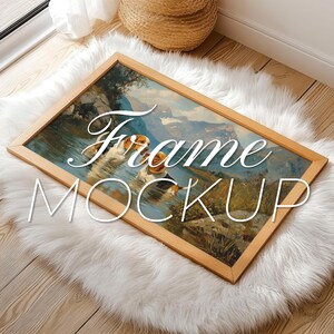 Puede incluir: Un marco de madera con una pintura de paisaje de un lago y montañas. El marco está sobre una alfombra blanca y esponjosa. El texto "Frame Mockup" está escrito en blanco sobre la alfombra.