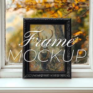 Könnte beinhalten: Schwarzer Bilderrahmen mit einem detaillierten, verzierten Design. Der Rahmen steht auf einer weißen Fensterbank mit einem verschwommenen Bild von Herbstlaub im Hintergrund. Der Text "Frame Mockup" ist über das Bild gelegt.