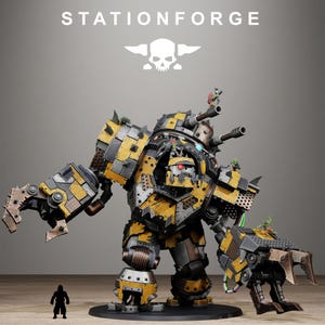 May include: A large model of a war machine in yellow, black, and grey, with multiple cannons and a claw arm. The model has a skull logo and the text "STATIONFORGE". A small figure is at the base. The model is highly detailed.