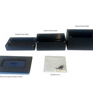 May include: Black rectangular boxes with varying depths: 19mm, 40mm, and 60mm. The image also shows a display with a dark blue screen and a bag of screws. Text on the image reads: "Standard 19mm Depth", "Optional 40mm Depth", "Optional 60mm Depth", "Shown with optional display installed", and "Included screws".