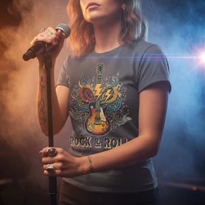 May include: A gray t-shirt with a colorful graphic of a guitar, lightning bolt, and musical notes. The words "ROCK & ROLL" are printed below the graphic. The shirt is short-sleeved.