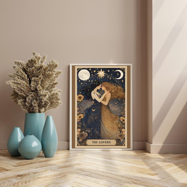 The Lovers Sapphic Art Print, Lesbian Wedding Gift, Whimsigoth Decor, Queer Art Poster. A beautifully illustrated sapphic art print that blends whimsigoth decor, celestial romance, and vintage aesthetics. Featuring two lovers entwined beneath a dreamy night sky, this piece radiates warmth, connection, and cosmic harmony. Displayed in white frame next to large vase of pampas against a neutral wall sitting on a herringbone wood floor.