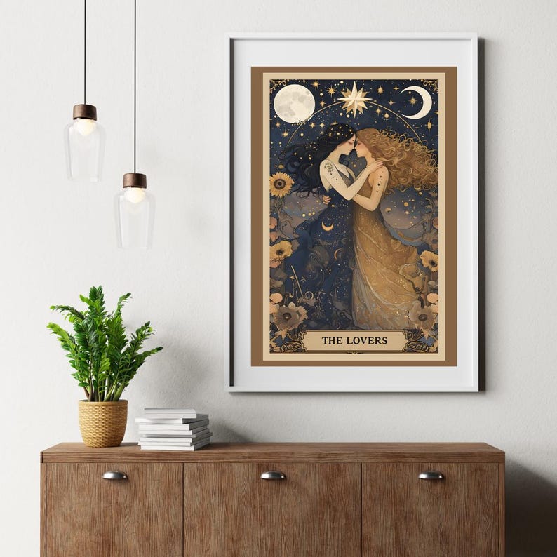 The Lovers Sapphic Art Print, Lesbian Wedding Gift, Whimsigoth Decor, Queer Art Poster. A beautifully illustrated sapphic art print that blends whimsigoth decor, celestial romance, and vintage aesthetics. Featuring two lovers entwined beneath a dreamy night sky, this piece radiates warmth, connection, and cosmic harmony. Displayed in white frame hung above retro console table with books and plant on top and modern hanging light fixture next to the framed poster.