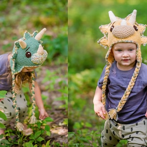 Puede incluir: Dos ni&ntilde;os con sombreros de dinosaurio de ganchillo hechos a mano con cuernos, ojos y orejeras. Los sombreros son en tonos verdes y amarillos. Los ni&ntilde;os visten camisas grises y pantalones estampados. Los sombreros tienen lazos trenzados con borlas.