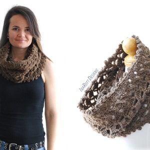 May include: A brown crocheted infinity scarf with a lacy pattern. The scarf is shown on a model and on a mannequin.